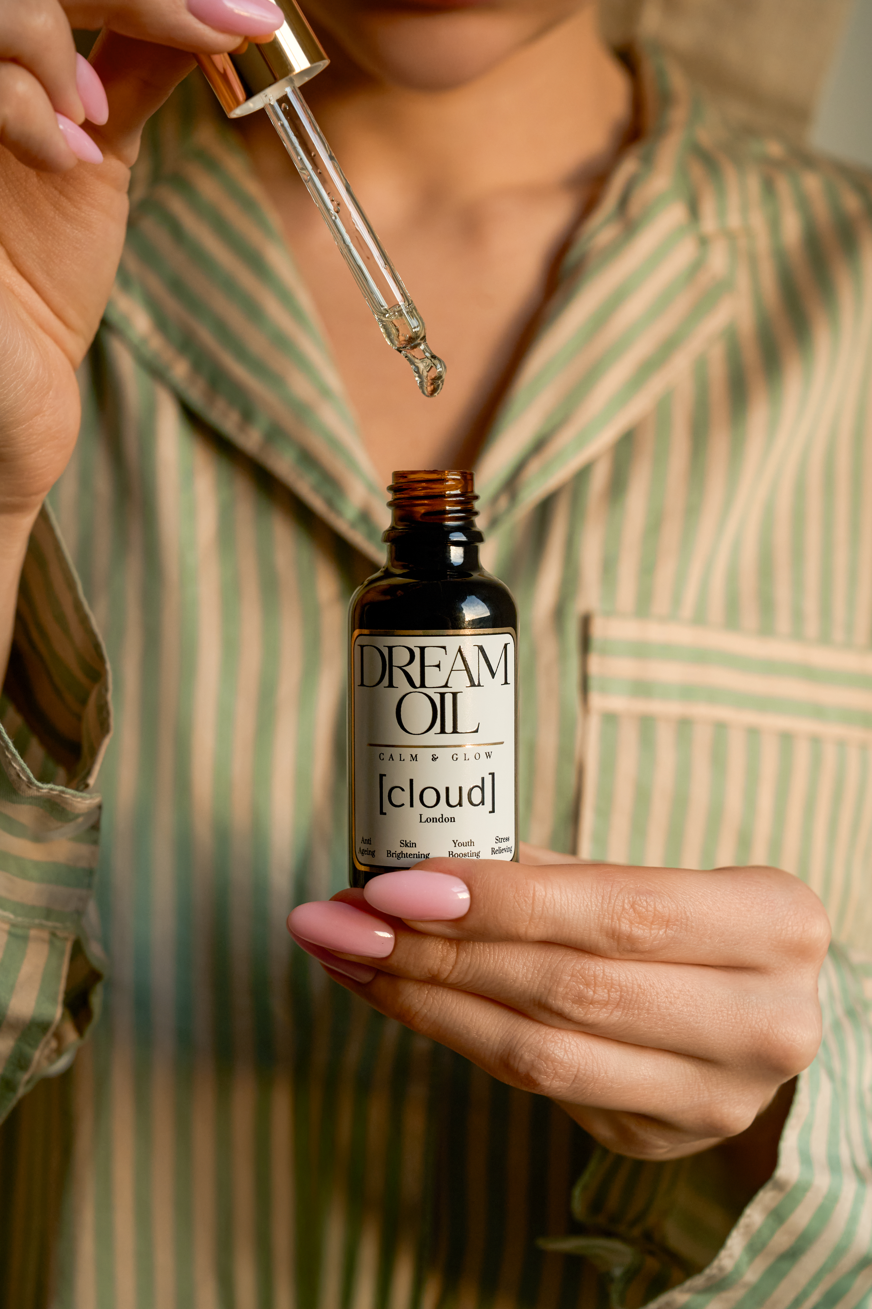 Dream Oil being used by a woman in pyjamas.